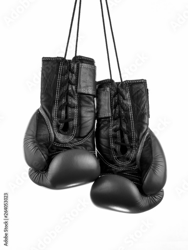  black boxing gloves hanging on the wall, close-up. © Lumppini