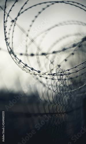 Gloomy abstract blurred background with barbed wire