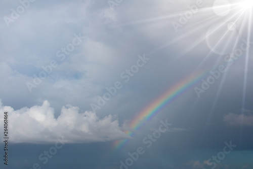 Rainbow in the blue sky with lighting flare