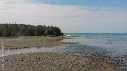 Cinematic drone / aerial footage moving forwards showing a forest and a bay in the cost of Kingsburg, Nova Scotia, Canada during summer season. photo