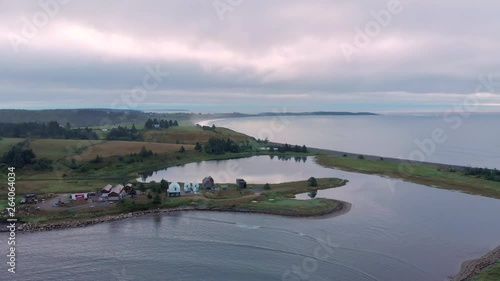 Cinematic drone / aerial footage descending showing some farms, the ocean and a few chalets in Kingsburg, Nova Scotia, Canada during summer season. photo