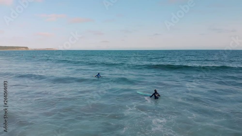 Cinematic drone / aerial rotating footage showing a couple of surfers at Cole Harbour coast in Lawrencetown, Nova Scotia, Canada during summer season. photo