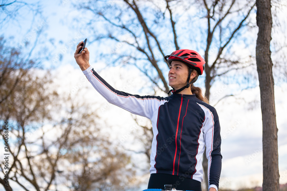 Happy cyclist taking selfie in park
