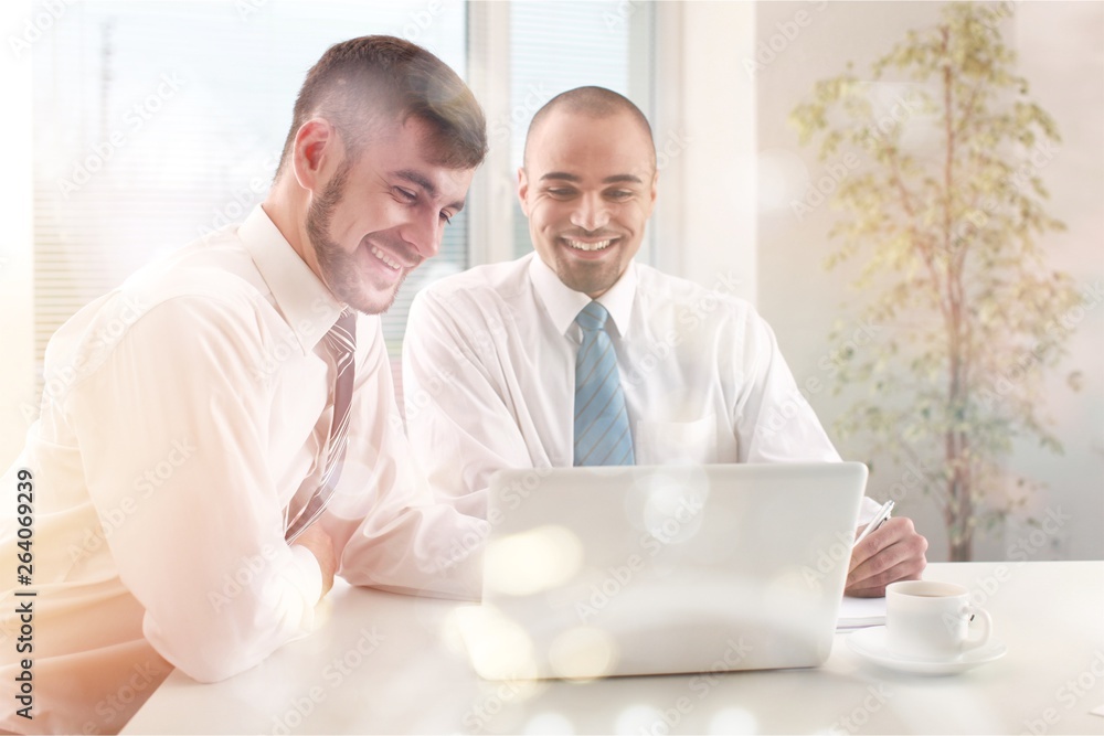Young men using laptop in office Young men using laptop in office