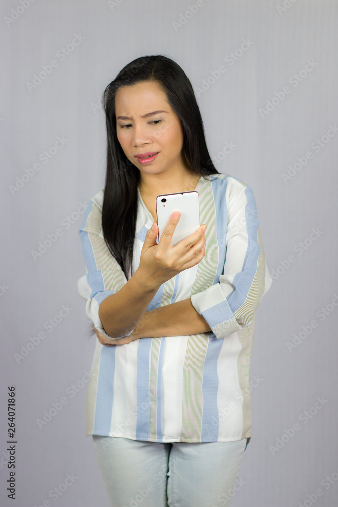cute beautiful woman in shirt acting playing on phone. Isolated on gray background cute beautiful woman in shirt acting playing on phone. Isolated on gray background