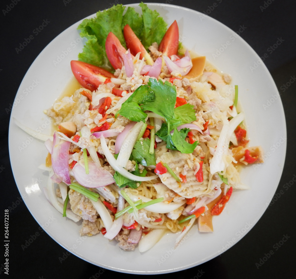 Instant noodle spicy salad food with herb pork and tomato vegetable celery mix on white plate top view Instant noodle spicy salad food with herb pork and tomato vegetable celery mix on white plate top view