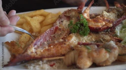 Eating South Africa rock lobster and seafood platter with butter sauce photo