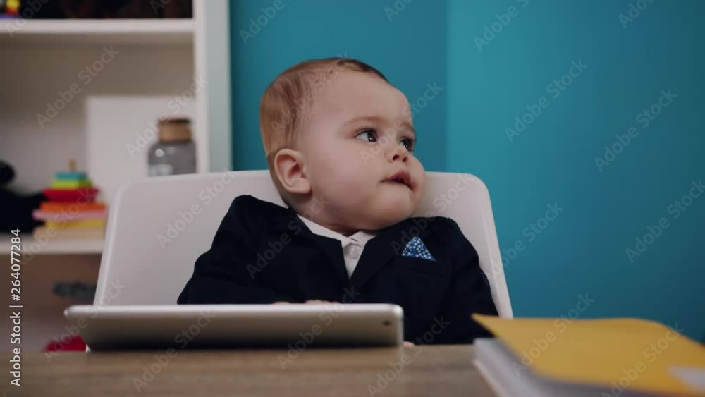 In office little boss boy businessman use tablet computer sitting play creative job work child computer education young suit cute career confident close up slow motion In office little boss boy businessman use tablet computer sitting play creative job work child computer education young suit cute career confident close up slow motion