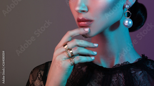 beautiful fashion model wearing elegant jewelry in color light photo