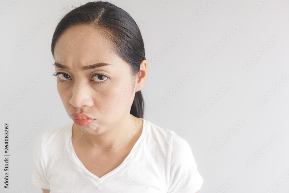 Sulk and grumpy face expression of woman in white t-shirt. Concept of offended peevish and sulky. Sulk and grumpy face expression of woman in white t-shirt. Concept of offended peevish and sulky.