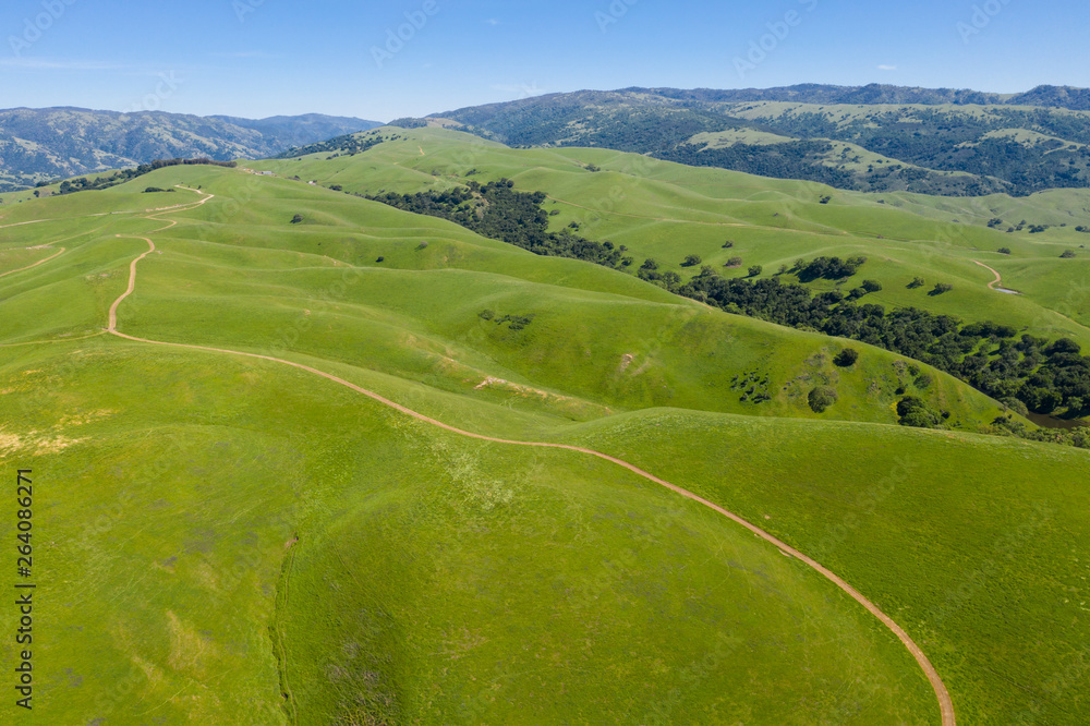 An aerial view of rolling hills in Northern California's tri-valley region shows lush, green grass that flourished after a wet winter. This beautiful area generally has a very hot, dry climate. 