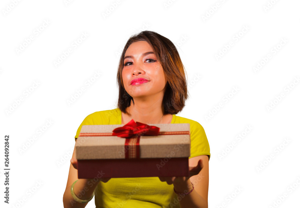 portrait of young happy and beautiful Asian Indonesian woman giving or receiving Christmas present or birthday gift box with red ribbon excited and cheerful smiling