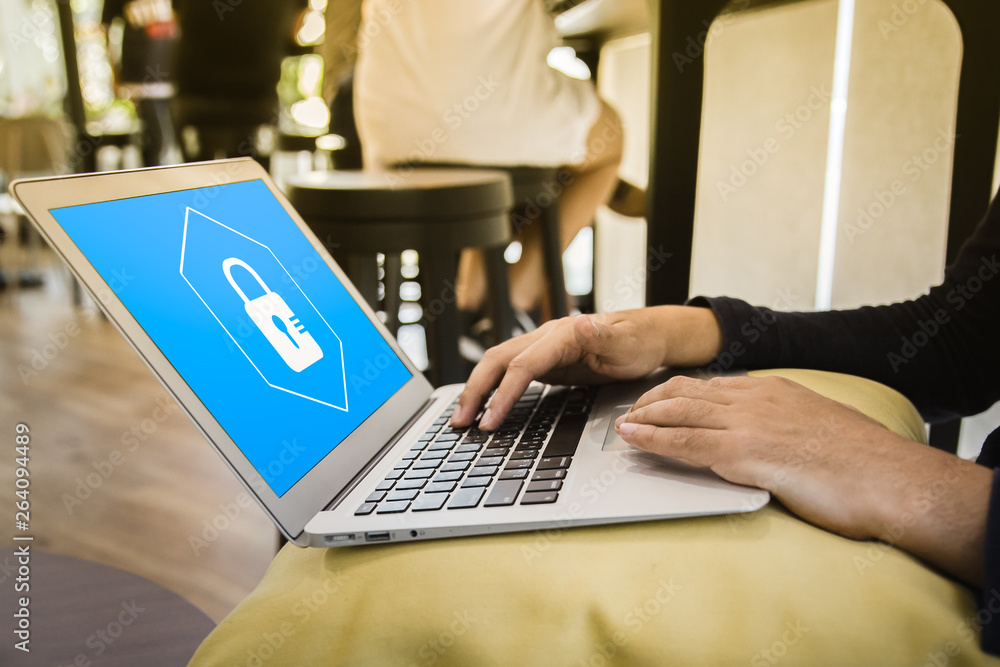 Business man working at a coffee shop with a laptop. elect the icon security on the virtual display. Business man working at a coffee shop with a laptop. elect the icon security on the virtual display.