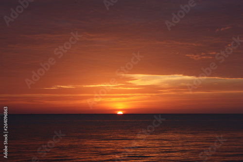 A red and yellow sunset over the ocean in Thailand © Robert