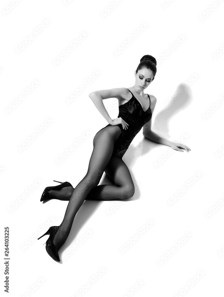 Beautiful fashion model in black swimsuit and hosiery. Young and beautiful woman posing in studio. Beautiful fashion model in black swimsuit and hosiery. Young and beautiful woman posing in studio.