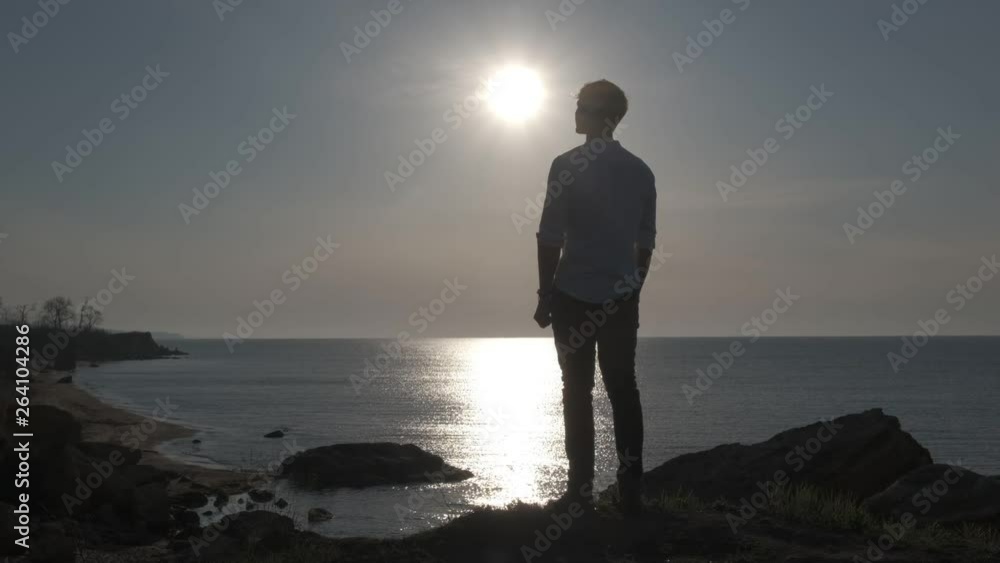 the guy on the beach looks at the sunrise the guy on the beach looks at the sunrise