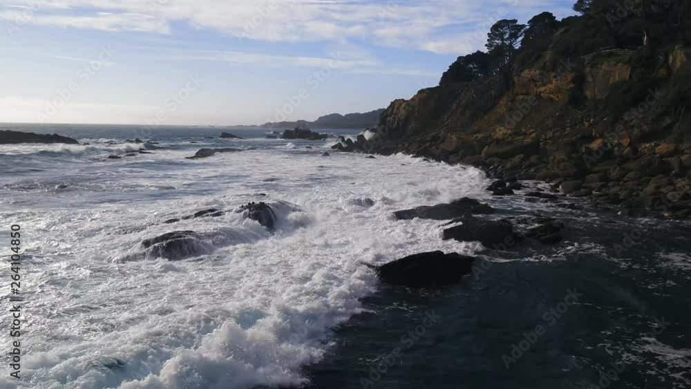 Aerial views of a rocky California Coastline with crashing, deep-blue waves on a cool dreary day Aerial views of a rocky California Coastline with crashing, deep-blue waves on a cool dreary day