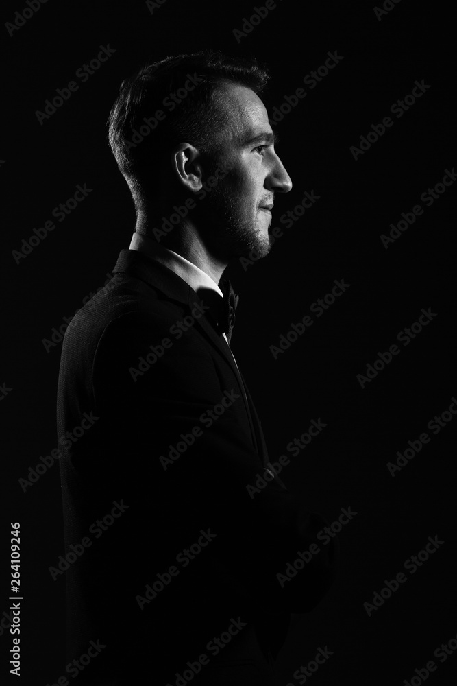 Portrait of a young  man in profile on a dark background.
