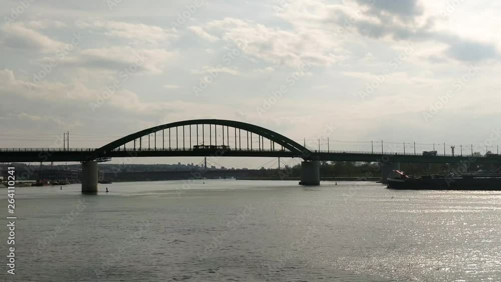 Barge moving under a bridge as a train passes by in Belgrade Serbia Barge moving under a bridge as a train passes by in Belgrade Serbia