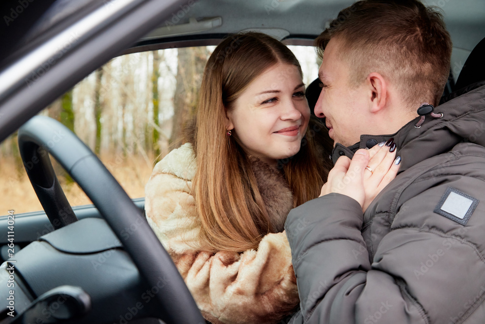 Ordinary cute couple in the car and autumn forest background Ordinary cute couple in the car and autumn forest background