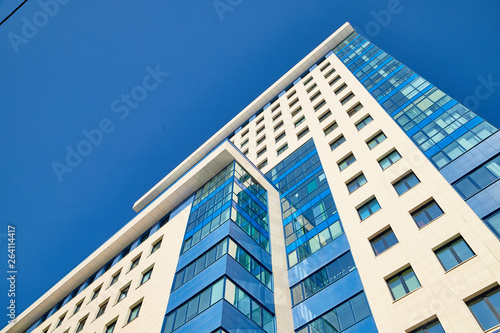 Modern large blue building with large Windows and blue sky above it