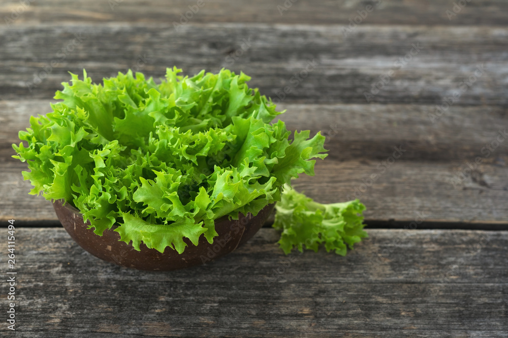 fresh lettuce leaves in a bowl on wooden background fresh lettuce leaves in a bowl on wooden background