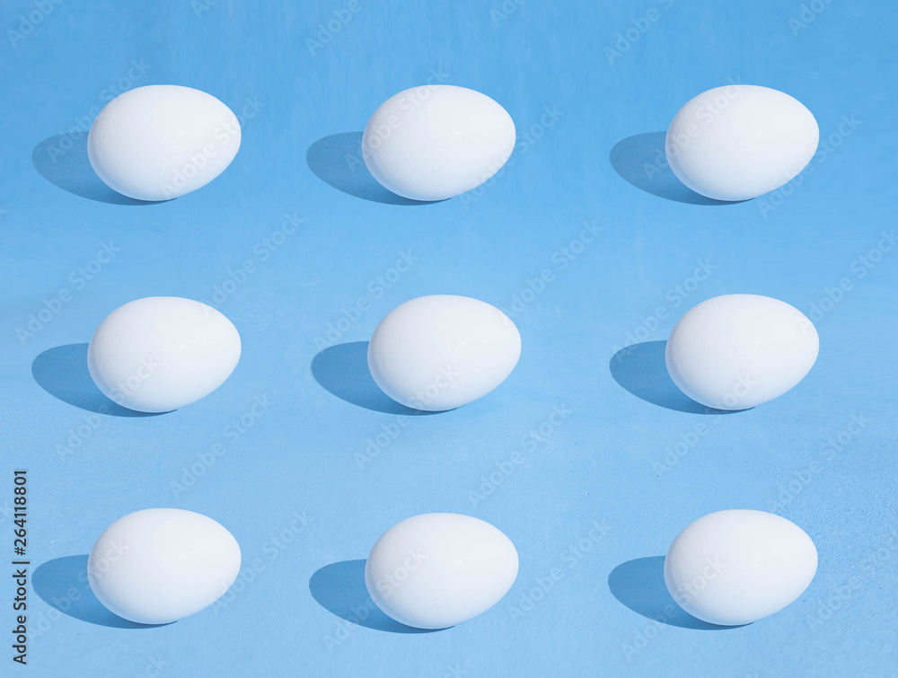 Food background made of white Easter eggs on a blue backdrop Food background made of white Easter eggs on a blue backdrop