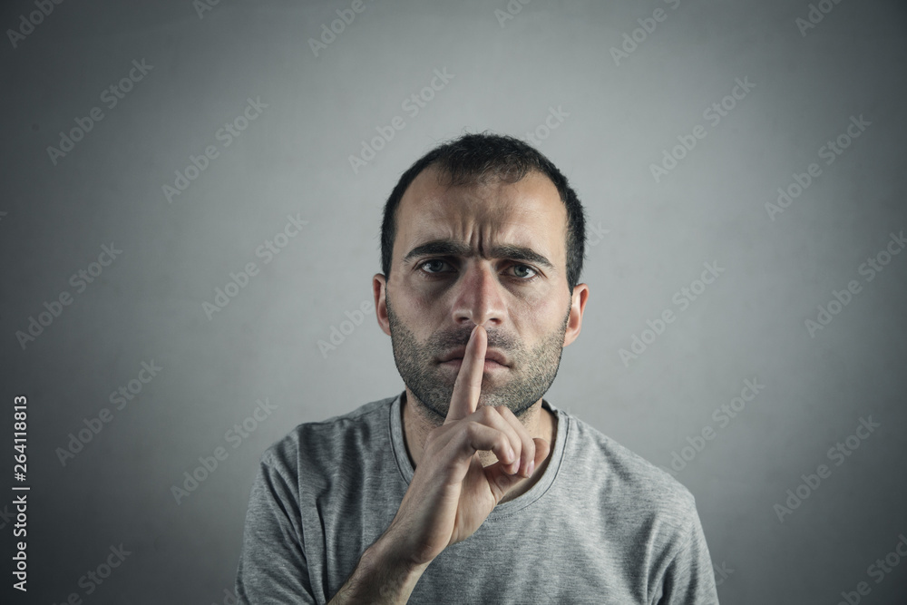 Caucasian serious man making silence gesture. Caucasian serious man making silence gesture.