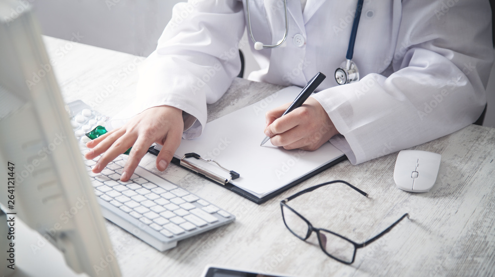 Doctor writing in a clipboard at clinic. Doctor writing in a clipboard at clinic.