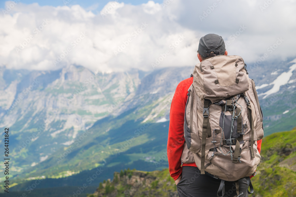 Hiker traveling in Alps. Alpine peaks landskape background. Jungfrau, Bernese highland. Sport, tourism and hiking concept. Hiker traveling in Alps. Alpine peaks landskape background. Jungfrau, Bernese highland. Sport, tourism and hiking concept.