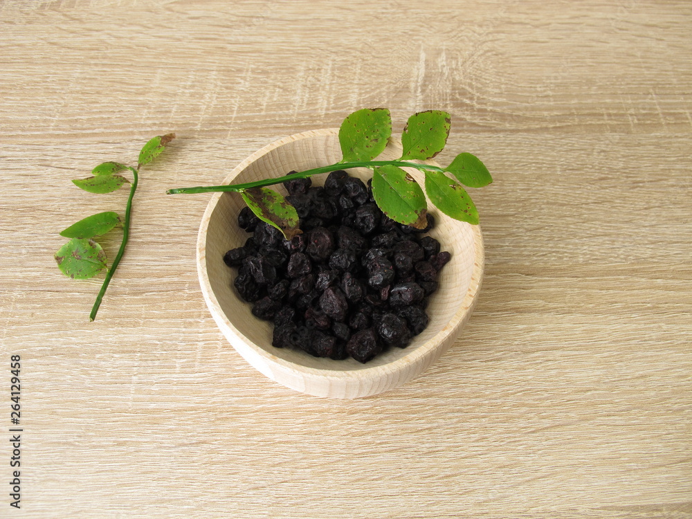 Getrocknete Heidelbeeren in einer Holzschüssel Getrocknete Heidelbeeren in einer Holzschüssel