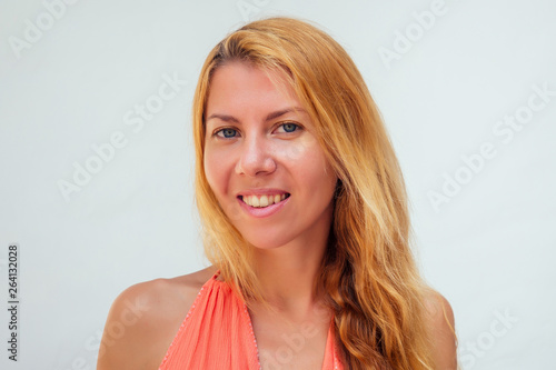 close up portrait of young woman with long blond damaged dry hair split ends and big blue eyes is looking at camera on isolated background. unsuccessful hair coloring