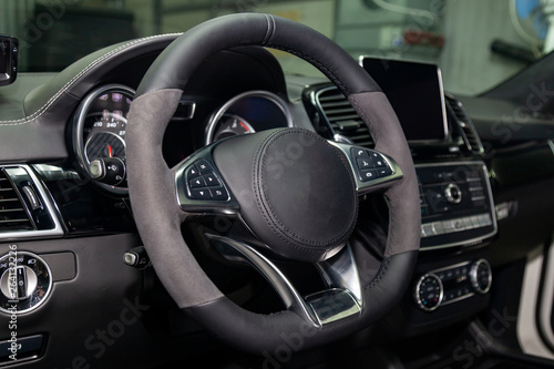 Interior view with steeering wheel and dashboard of luxury very expensive new white car stands in the washing box after detailing in vehicle repair workshop © Aleksandr Kondratov