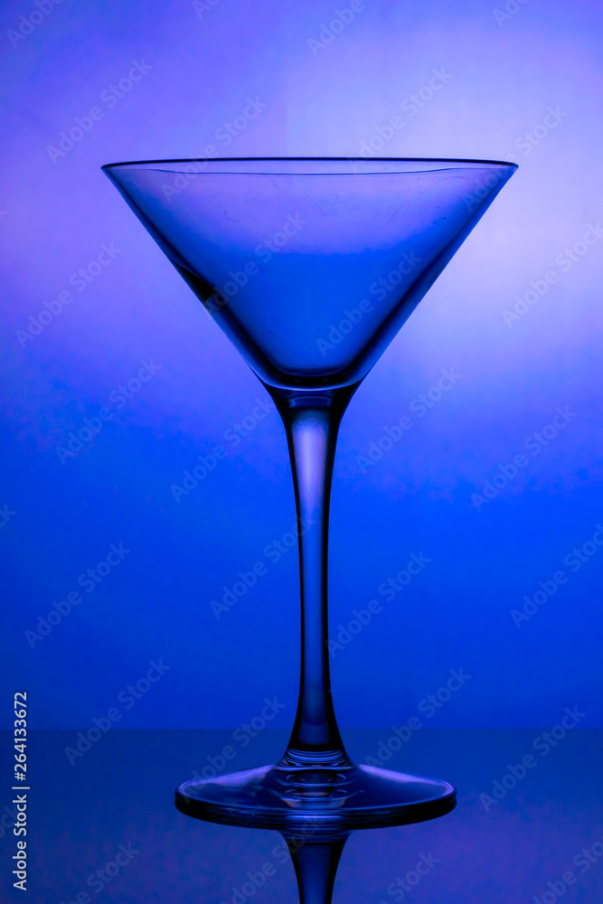 Cocktail glass, the stemmed glass is lit with blue light Cocktail glass, the stemmed glass is lit with blue light