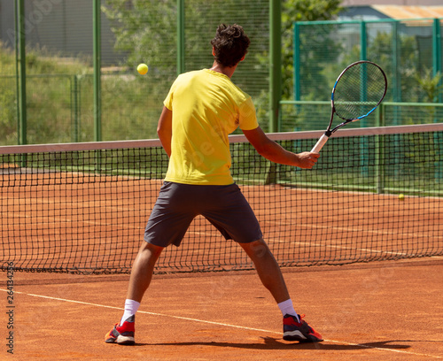 A man plays tennis on the court in the park