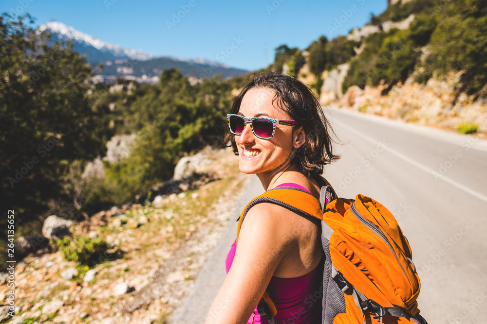 A girl with a backpack is on the road. A girl with a backpack is on the road.