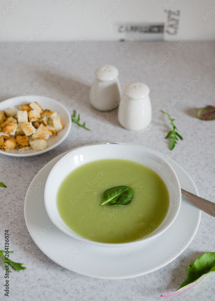 Fresh green Vegetable cream soup. Green Broccoli cream soup on white bolw on the white background Fresh green Vegetable cream soup. Green Broccoli cream soup on white bolw on the white background