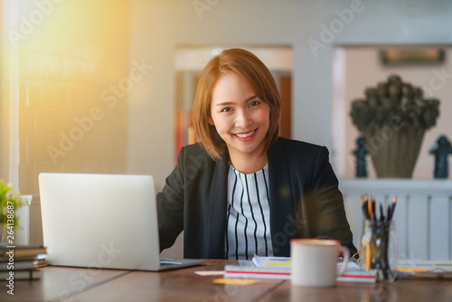 Young business woman using on the laptop while sitting at her working place.	
