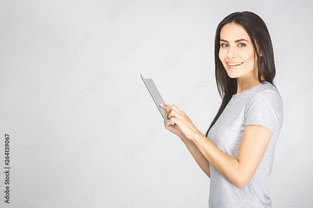 Portrait with copy space empty place of pretty charming confident trendy woman in casual having tablet in hands looking at camera isolated on white background. Portrait with copy space empty place of pretty charming confident trendy woman in casual having tablet in hands looking at camera isolated on white background.