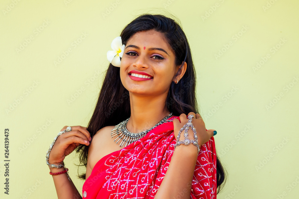 Closeup headshot portrait of attitude confident smiling happy pretty young woman background of blurred trees, plumeria flowers. Positive human emotion facial expression feelings Closeup headshot portrait of attitude confident smiling happy pretty young woman background of blurred trees, plumeria flowers. Positive human emotion facial expression feelings