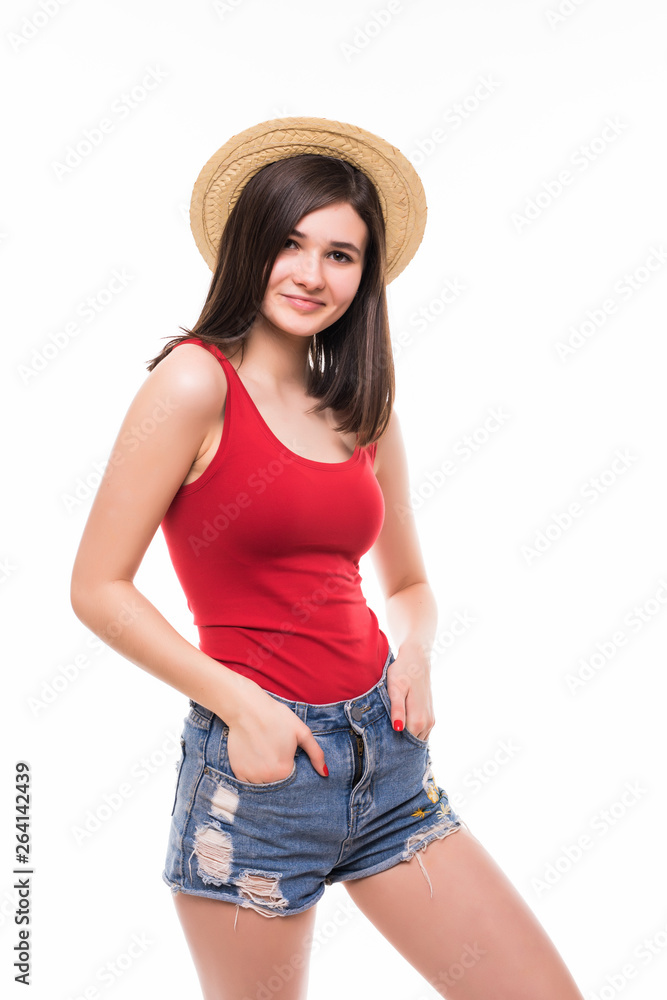 Portrait of a smiling attractive woman in summer clothes and hat posing while standing and looking at camera isolated over white background Portrait of a smiling attractive woman in summer clothes and hat posing while standing and looking at camera isolated over white background