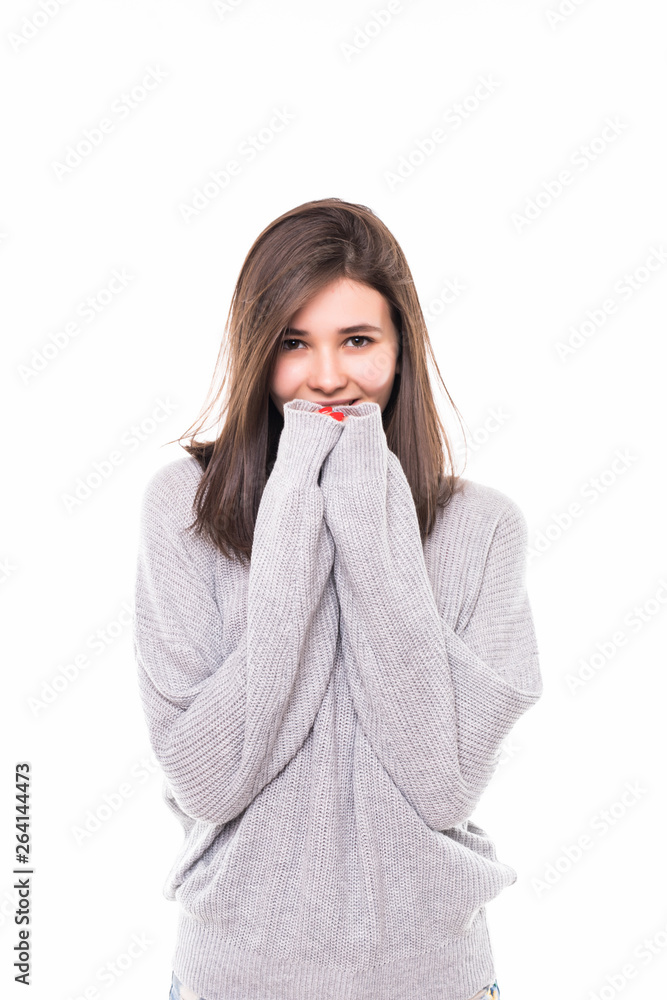 Smiling woman wearing in gray sweater standing against isolated gray background. Smiling woman wearing in gray sweater standing against isolated gray background.