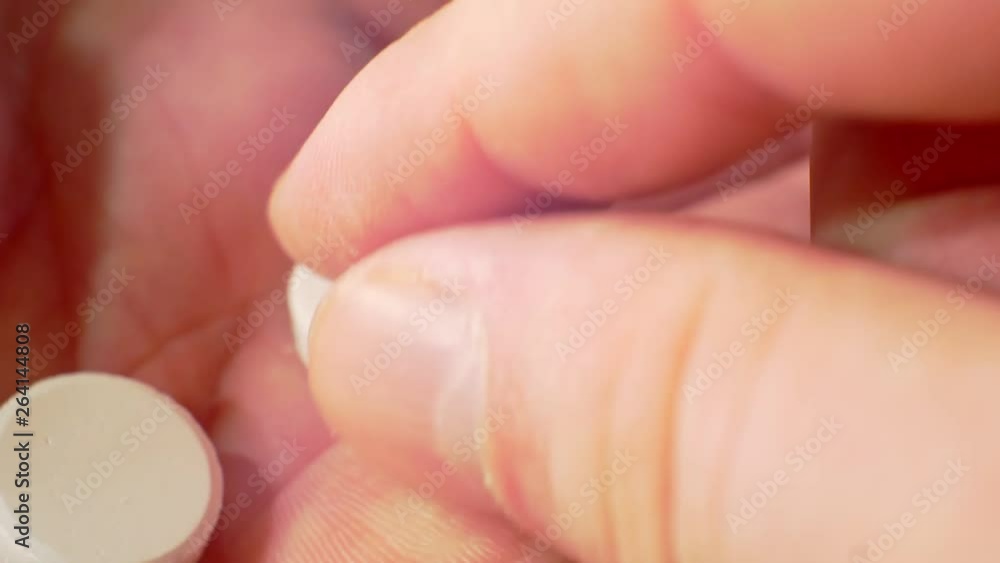 white pills on a human hand.close-up white pills on a human hand.close-up