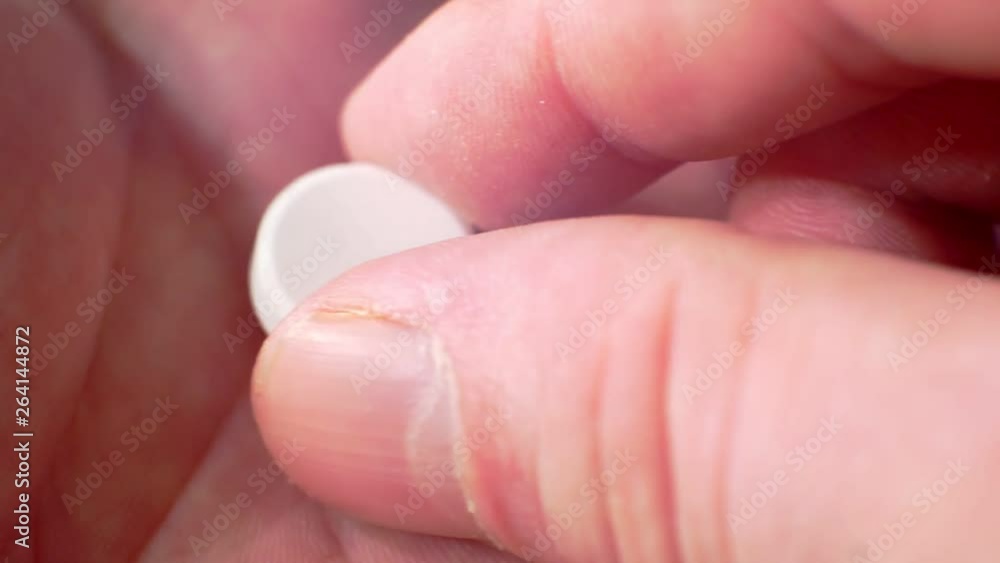 white pills on a human hand.close-up white pills on a human hand.close-up