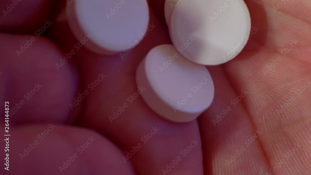 several white large pills on the human palm.close-up, shallow depth of field. several white large pills on the human palm.close-up, shallow depth of field.
