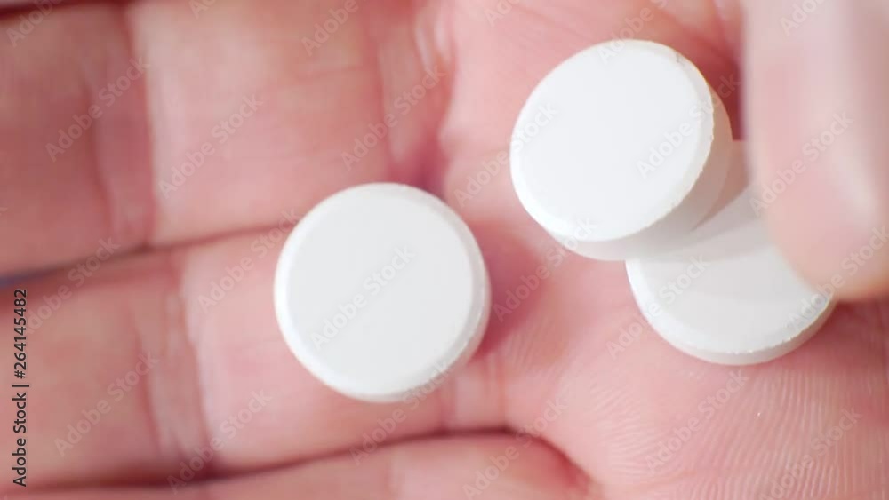 several large white tablets fall out of a plastic flask in the palm.close-up.shallow depth of field several large white tablets fall out of a plastic flask in the palm.close-up.shallow depth of field