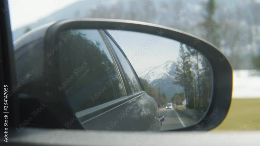 4K video of snow covered Norwegian mountain seen through the side mirror of a dark car in motion. 4K video of snow covered Norwegian mountain seen through the side mirror of a dark car in motion.