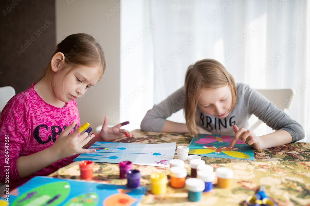 Two sisters little girls drawing with fingers on paper. Play, fun, childhood. Montessori school Two sisters little girls drawing with fingers on paper. Play, fun, childhood. Montessori school