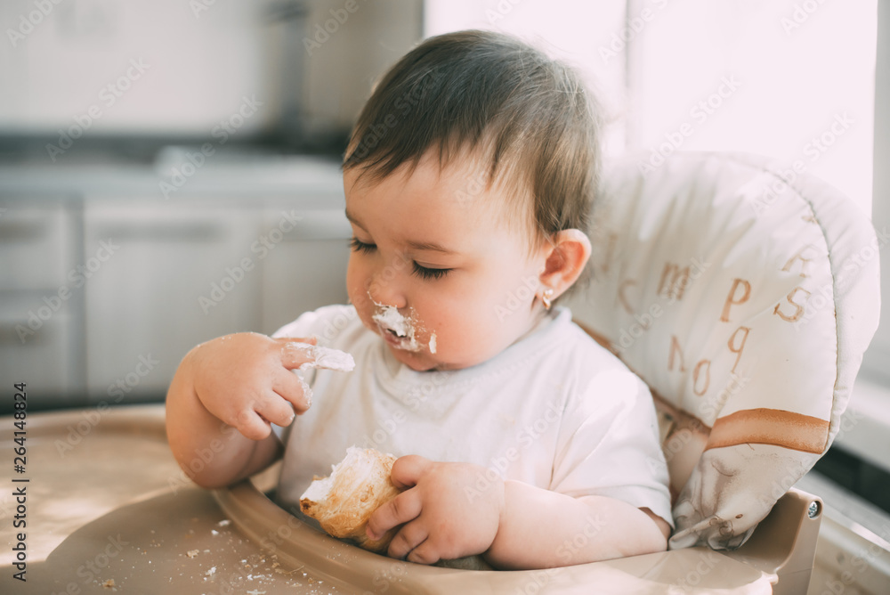 baby in the kitchen eagerly eating the delicious cream horns, filled with a vanilla cream baby in the kitchen eagerly eating the delicious cream horns, filled with a vanilla cream