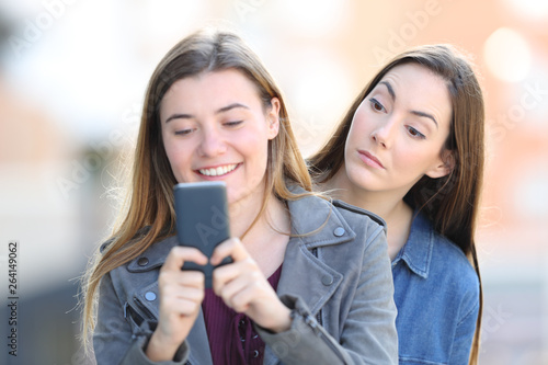 Fotografi Gossip woman spying the phone of a friend